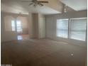 Spacious carpeted living room with vaulted ceilings, featuring an open layout and plenty of natural light from the windows at 2028 E Libby St, Phoenix, AZ 85022