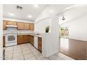 Bright kitchen featuring wooden cabinets, white appliances, tile floors, and access to the backyard at 2031 S 86Th Ln, Tolleson, AZ 85353
