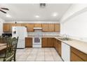 Spacious kitchen featuring white appliances, wooden cabinets, tile floors, and ample counter space at 2031 S 86Th Ln, Tolleson, AZ 85353
