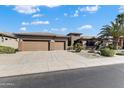 Attractive single-story home showcasing manicured landscaping and a convenient three-car garage at 20609 N Canyon Whisper Dr, Surprise, AZ 85387