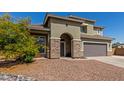 Beautiful two-story home featuring desert landscaping, a stone-accented entrance, and an attached two-car garage at 2136 W Pickett Ct, San Tan Valley, AZ 85144