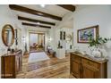 Bright home foyer featuring wood floors, beamed ceilings, and elegant furnishings and decor at 3086 S First Water Ln, Gold Canyon, AZ 85118