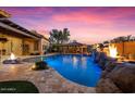 Stunning backyard pool with rock features, outdoor kitchen, and beautifully designed landscaping at 32020 N 20Th Dr, Phoenix, AZ 85085