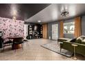Eclectic living room featuring bold wallpaper, stylish furnishings, and ample natural light through large windows at 3516 W Brown St, Phoenix, AZ 85051