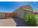 Side yard with gravel, a wooden fence, and access gate to the backyard at 3597 E Appaloosa Dr, San Tan Valley, AZ 85140