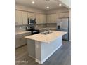 Modern kitchen with stainless steel appliances, gray cabinets, and a large center island at 36939 W Santa Maria St, Maricopa, AZ 85138