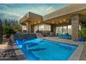 Inviting backyard pool with a stone accent wall and modern outdoor furniture, perfect for relaxation at 38199 N Tranquil Way, Carefree, AZ 85377