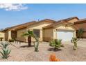 Exterior view of a one-story tan home featuring desert landscaping and a tile roof at 45068 W Alamendras St, Maricopa, AZ 85139