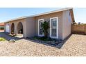 Side view of home's front exterior features landscaped accents, an arched entryway and shuttered windows at 5221 W Garden Dr, Glendale, AZ 85304