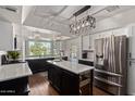 Modern kitchen with stainless steel appliances, an island, and pendant lighting at 544 W Thunderbird Rd, Phoenix, AZ 85023