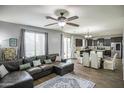 Open floor plan showcasing a living room with a ceiling fan and an adjacent dining area and dark brown kitchen at 6749 W Charter Oak Rd, Peoria, AZ 85381