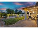 This backyard retreat boasts a pool, covered patio with seating, and lush landscaping at 7354 E Norwood St, Mesa, AZ 85207