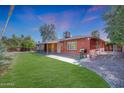 Backyard view with a well-maintained lawn, a covered patio, and a brick exterior at 8204 E Turney Ave, Scottsdale, AZ 85251