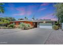 Charming red brick single-story home with a two-car garage and desert landscaping in front at 8204 E Turney Ave, Scottsdale, AZ 85251