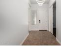 Bright home entry featuring tile floors, modern lighting, and a white front door at 1123 E Buckingham Ave, Gilbert, AZ 85297