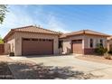 Spacious home exterior featuring a tile roof, desert landscaping, and a circular driveway at 1123 E Buckingham Ave, Gilbert, AZ 85297