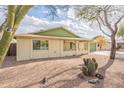 A cozy single-story home featuring desert landscaping with decorative green accents on the roof and garage at 1237 E Gemini Dr, Tempe, AZ 85283