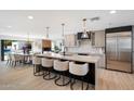 A modern kitchen is showcased with a large island, seating, stainless steel appliances and adjacent dining area at 12620 N 70Th St, Scottsdale, AZ 85254