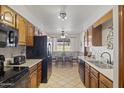 Functional kitchen featuring wood cabinets, black appliances, and tile flooring at 1459 S Mara Dr, Apache Junction, AZ 85120