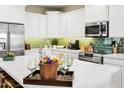 Well-equipped kitchen with stainless steel appliances and green backsplash at 1661 E Hampton Ln, Gilbert, AZ 85295
