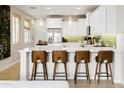Bright kitchen with white cabinets, quartz countertops and island seating at 1661 E Hampton Ln, Gilbert, AZ 85295
