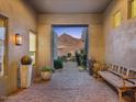 Covered entrance showing bench and plants looking to a mountain view through the home's courtyard at 16670 N 109Th Way, Scottsdale, AZ 85255
