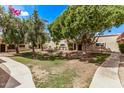 View of the grassy common area surrounded by multiple tan townhomes at 17242 N 16Th Dr # 6, Phoenix, AZ 85023