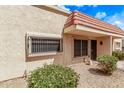 Tan home with a red tile roof, security bars, and xeriscaping for easy maintenance in a sunny environment at 17242 N 16Th Dr # 6, Phoenix, AZ 85023