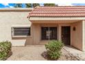 Tan home featuring a red tile roof, security bars on the windows, and low-maintenance landscaping at 17242 N 16Th Dr # 6, Phoenix, AZ 85023