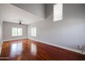 Bright living room features hardwood floors, large windows, a high ceiling and a modern ceiling fan at 1731 E Evans Dr, Phoenix, AZ 85022