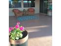 Cozy outdoor patio featuring wicker chairs, a rug, and potted flowers, perfect for relaxing in the Arizona sun at 17946 W Buena Vista Dr, Surprise, AZ 85374