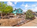 View of the backyard and exterior of the home showing rock features and mature trees at 1822 N Sunaire Cir, Mesa, AZ 85205