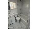 Bright bathroom with a shower-tub combo, modern vanity, and sleek marble-look tile flooring at 2027 E Michelle Dr, Phoenix, AZ 85022