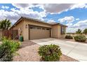 Charming single-story home with a well-manicured lawn and a spacious two-car garage at 20941 E Pecan Ln, Queen Creek, AZ 85142
