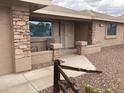 Cozy front porch adorned with decorative stone pillars, a charming walkway, and well-maintained desert landscaping at 2152 S Olivewood --, Mesa, AZ 85209