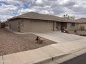 Charming single-story home with a desert landscape, stone accents, and a spacious driveway leading to a two-car garage at 2152 S Olivewood --, Mesa, AZ 85209