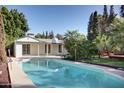 Inviting backyard with refreshing pool, covered patio, mature landscaping, and lush green lawn at 2533 E Flower St, Phoenix, AZ 85016