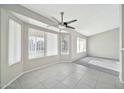 Bright living room featuring tile floors, large windows, and a ceiling fan at 5029 N 86Th Dr, Glendale, AZ 85305