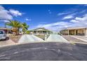 Wide shot showing the home's front with a spacious driveway and well-maintained desert landscaping at 67 S Amulet Ave, Mesa, AZ 85208