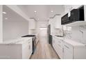 Bright kitchen featuring white cabinets, stainless steel appliances, and marble countertops at 7041 E Cypress St St, Scottsdale, AZ 85257