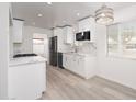 Well-lit kitchen with white cabinets, modern appliances, and a stylish hanging light fixture at 7041 E Cypress St St, Scottsdale, AZ 85257
