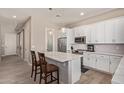 Modern kitchen featuring white cabinetry, stainless steel appliances, and a center island with seating at 8026 S 6Th Dr, Phoenix, AZ 85041