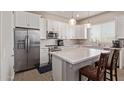 Modern kitchen featuring white cabinetry, stainless steel appliances, and a center island with seating at 8026 S 6Th Dr, Phoenix, AZ 85041