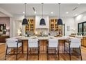 Bright kitchen with island, modern pendant lights, wooden cabinets, and hardwood flooring at 8220 E Sharon Dr, Scottsdale, AZ 85260