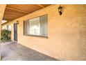 A covered front porch features a secure entry door and a view of the textured exterior wall at 1059 E 9Th Ave, Mesa, AZ 85204