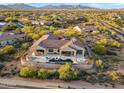 Expansive desert home featuring an outdoor pool, covered patio, and lush desert landscaping at 10799 E Florence Way, Scottsdale, AZ 85262