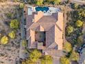 Stunning aerial view of the expansive tile roof home with a beautiful backyard pool and desert landscaping at 10799 E Florence Way, Scottsdale, AZ 85262