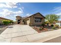 Welcoming single-story home with lush desert landscaping and charming architectural details at 11571 E Chevelon Trl, Gold Canyon, AZ 85118