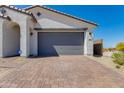 Exterior shot of a 2 car garage with gray door and brick paver driveway at 11738 S 173Rd Ln, Goodyear, AZ 85338