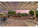View of the backyard and desert landscaping from the covered patio with brick pavers at 13841 W Nogales Dr, Sun City West, AZ 85375